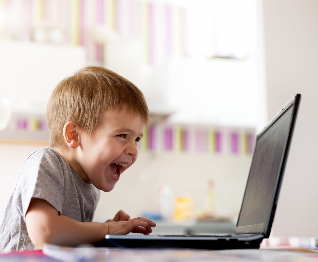 Child on laptop participating in teletherapy session