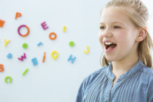 Happy school-aged girl speaking; fluency disorder