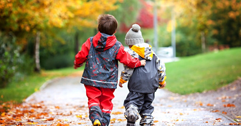 Two Boys Walking with Arms around each other on a Fall Day