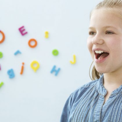 Happy school-aged girl speaking; fluency disorder