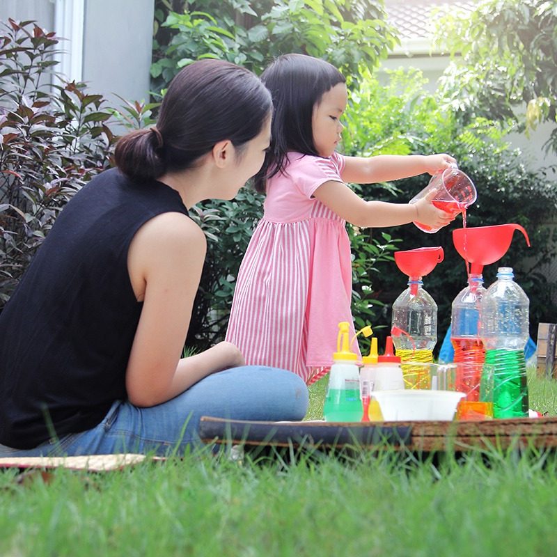 Mom supervising child conduct science experiment that helps language development