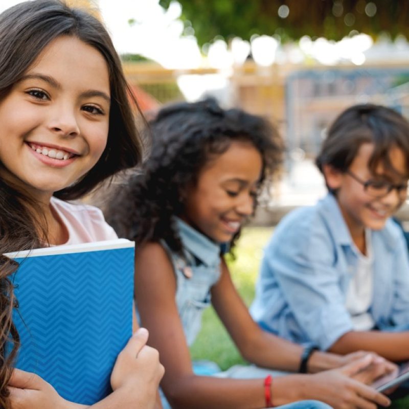 Smiling Kids Reading Outdoors