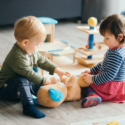 Toddlers Playing Together the Floor with a Toy