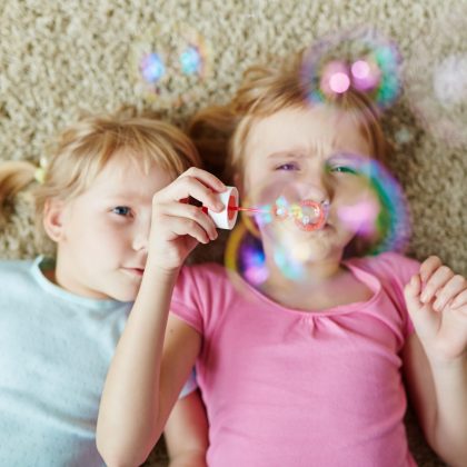 Young girls blowing bubbles at home
