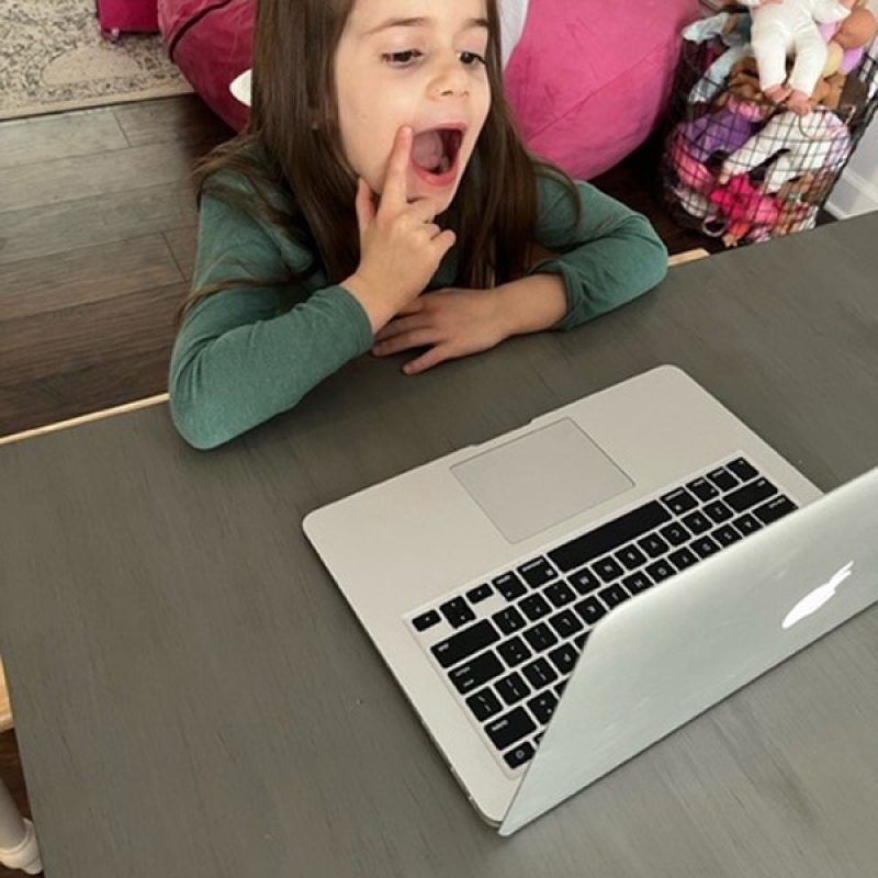 child doing speech teletherapy via laptop