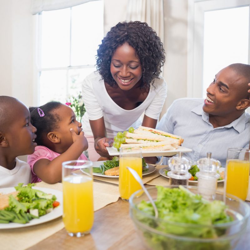 Family with young children at table enjoying meal together